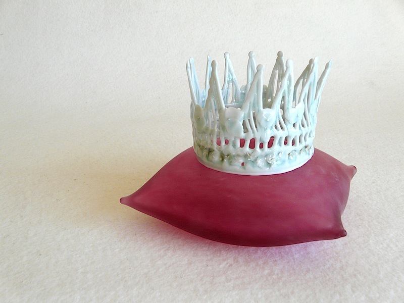 petite couronne en porcelaine sur un coussin en verre soufflé